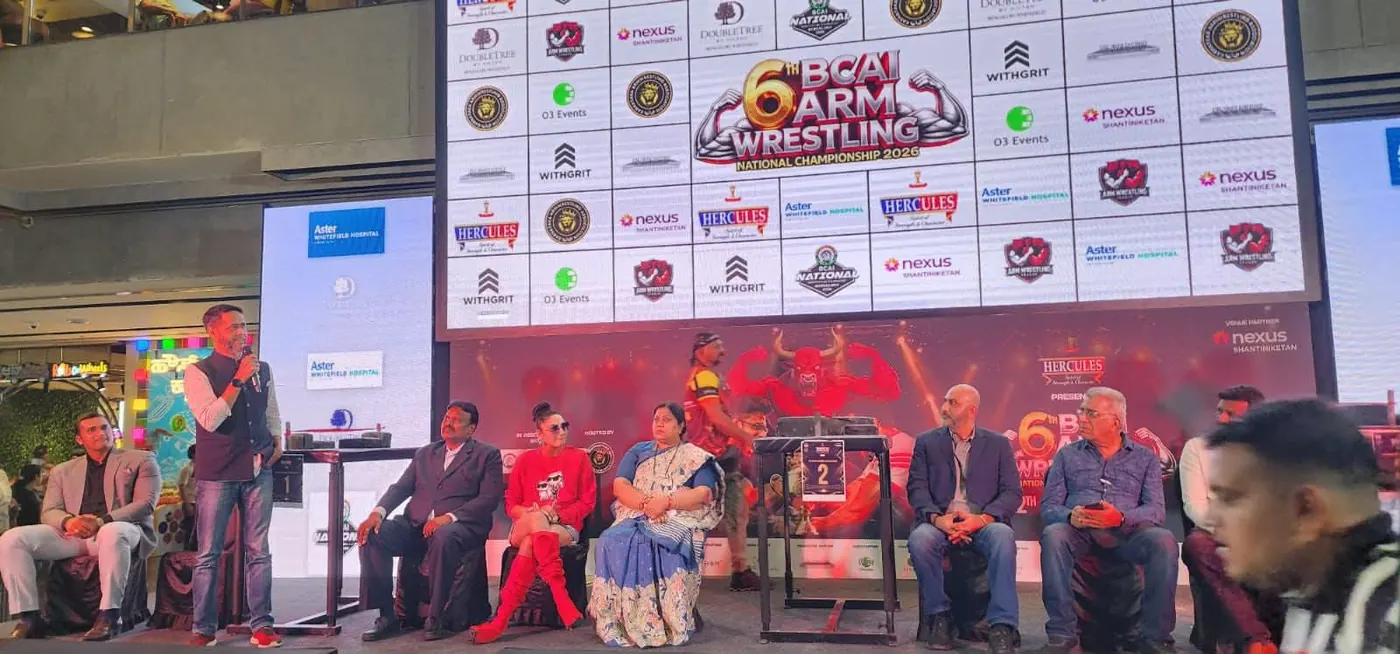 Dignitaries seated on stage at the 6th BCAI Arm Wrestling National Championship 2026 with sponsor backdrop including Icon Hotels hospitality partner